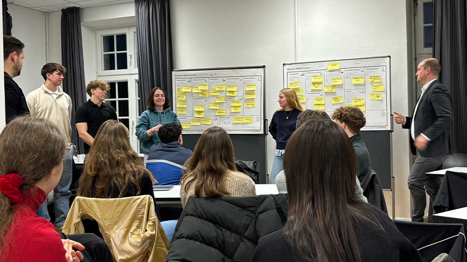 Gruppe von Studierenden präsentiert das Ergebnis ihrer Gruppenarbeit